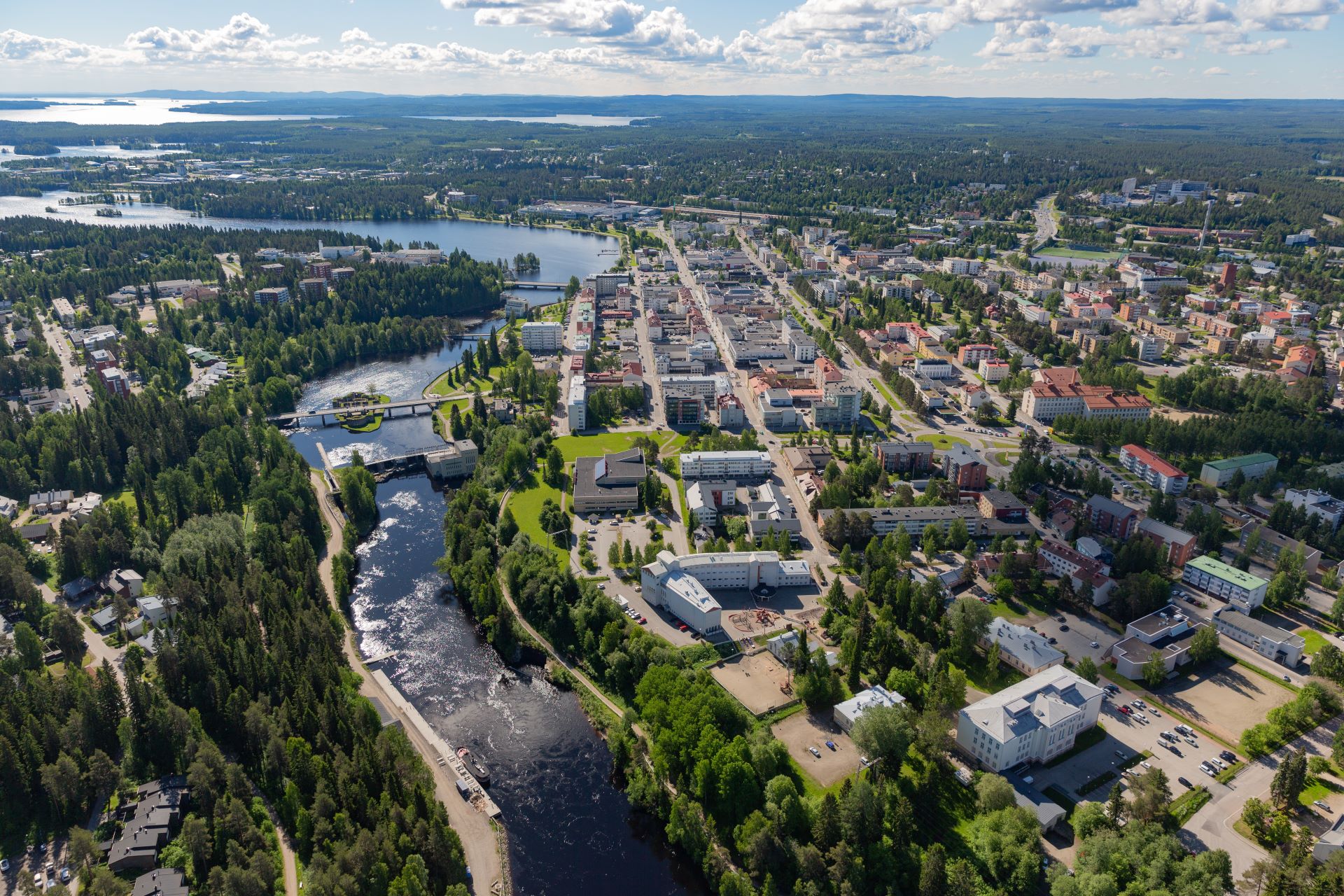 Leikkipuistossa hymyilevä lapsi katsoo kameraan