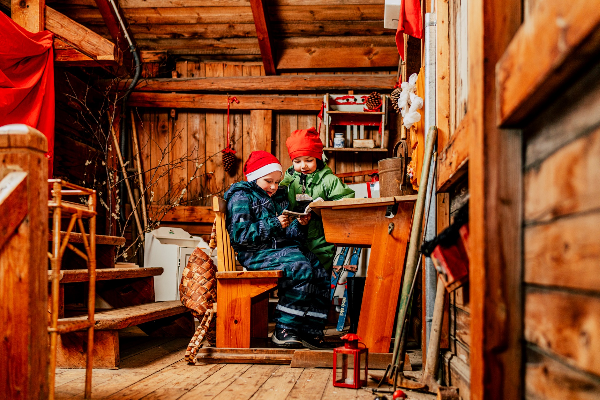 Kaksi tonttupoikaa lukevat kirjaa verstaassa