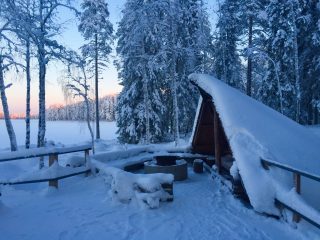 Ruuhijärven kota talvella illan hämärtyessä.