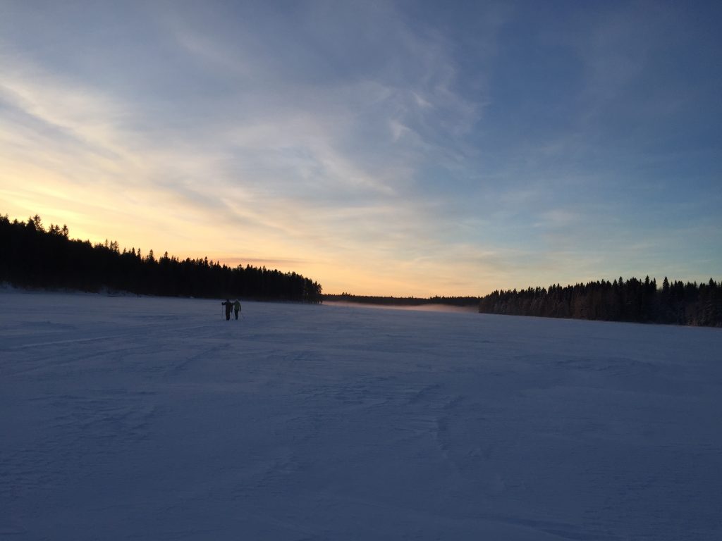 Kaksi hiihtäjää Rehjansalmella auringonlaskussa