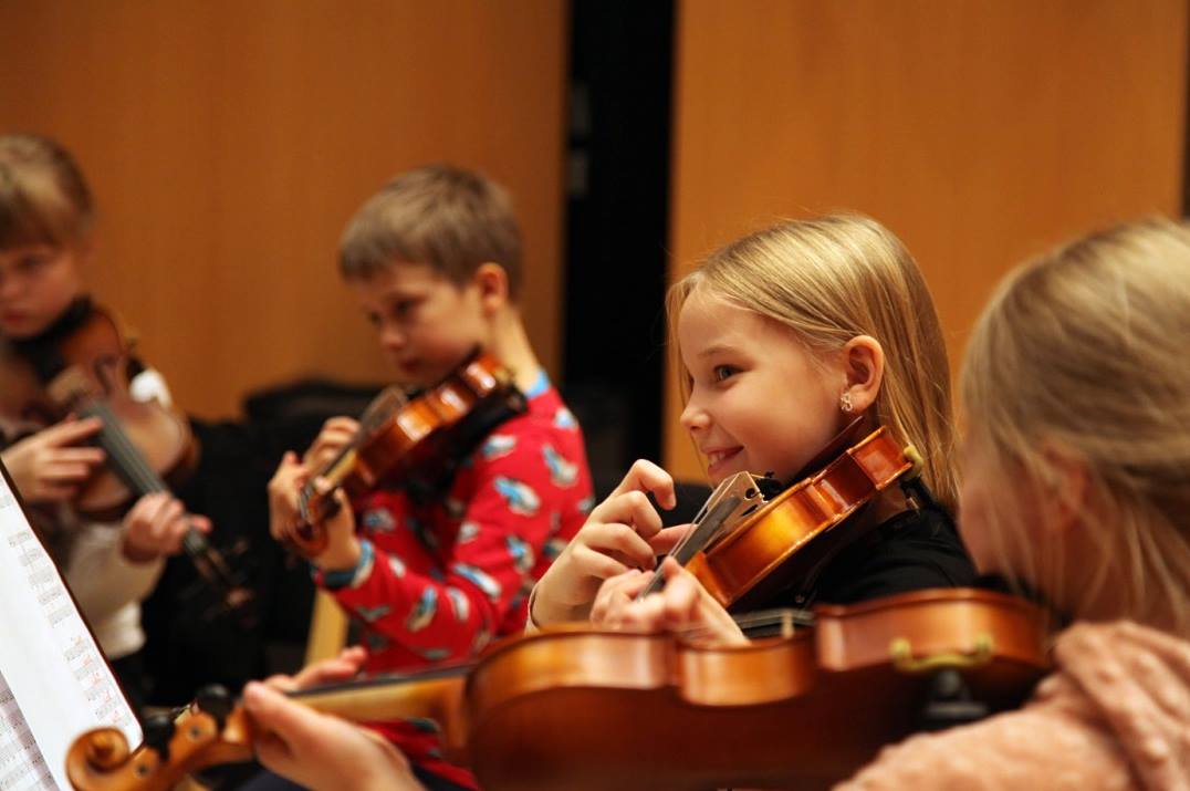 Lapset soittavat viulua orkesterissa