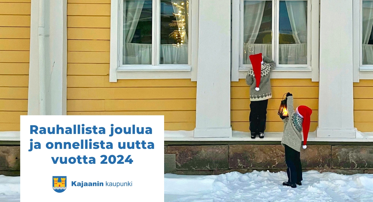 Tonttuja kurkistamassa Kajaanin Raatihuoneen ikkunasta.