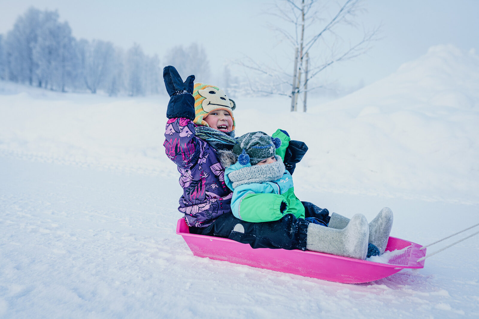 Lapsi vilkuttaa pulkassa